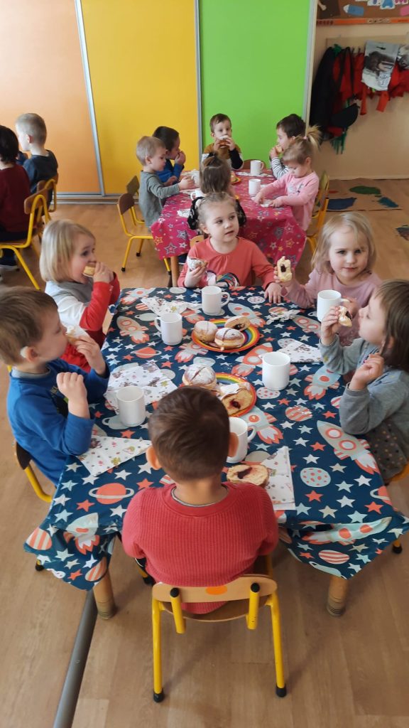 Grupa I - Dzieci przy stolikach degustują pączki