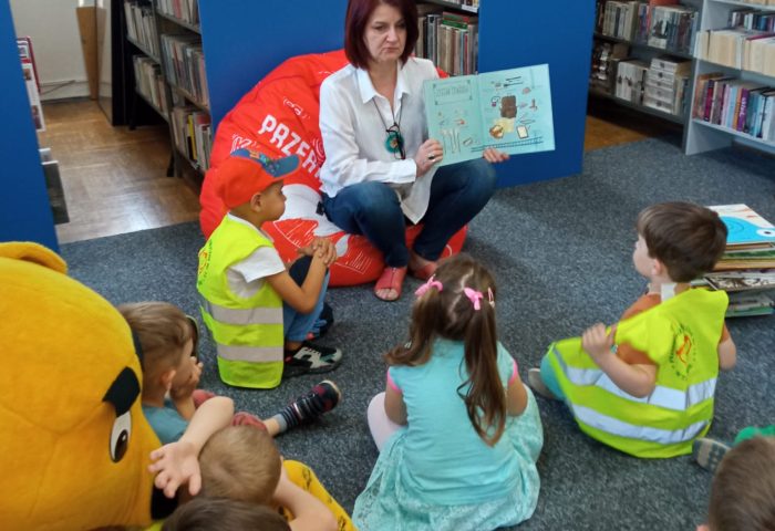Grupa II - Dzieci oglądają książkę z Panią bibliotekarką