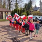 Grupa III - Dzieci na placu przedszkolnym z flagami