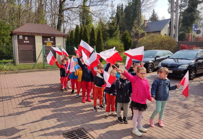 Grupa III - Dzieci na placu przedszkolnym z flagami