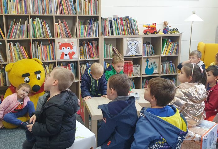 Grupa II - Dzieci oglądają książkę wspólnie z Panią bibliotekarką