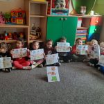 Grupa I - Dzieci siedzą na dywanie z rysunkami Kubusia