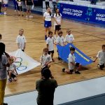 Dzieci trzymają flagę olimpijską i flagę Tarnowa