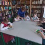Grupa IV - Dzieci przy stolikach z Panią bibliotekarką