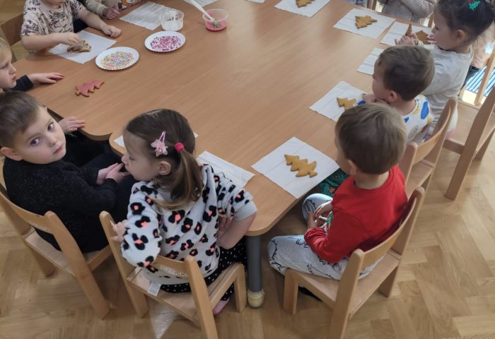 Grupa I - Dzieci przy wspólnym stole ozdabiają pierniki