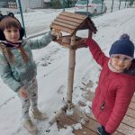 Grupa V-Dziewczynki wkładają do karmnika pożywienie dla ptaków