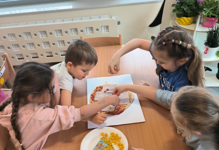 Grupa V- Dzieci posypują pizze kukurydzą