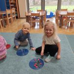 Grupa II - Dzieci na dywanie z guzikami