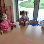 Grupa II - Dzieci przy stolikach zasadzają fasolę